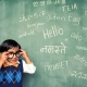 Child learning multiple languages written on a chalkboard.